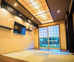 A traditional Japanese room with tatami flooring, sliding shoji doors, and a ceiling with a grid pattern. - Kyoran-gengetsu (Kyoto)