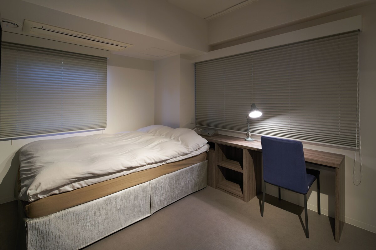 Ein Schlafzimmer mit einem Bett, einem Schreibtisch und einem Stuhl.