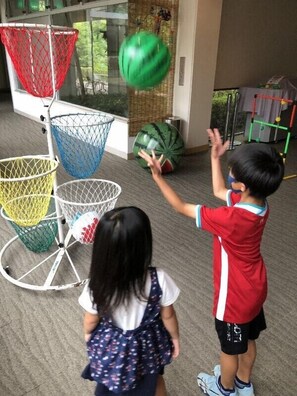 A child playing with a ball near a basketball hoop. - I&I Land (Shijonawate)