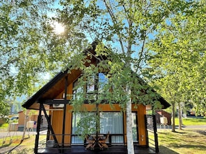 A modern wooden cabin with a sloped roof, large windows, and a covered outdoor seating area. - Bliss Cottage Sakura (Kutchan)