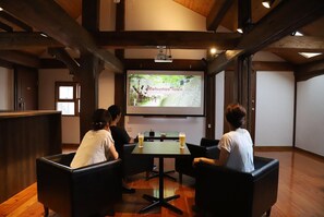 A conference room with a large screen displaying a presentation titled "Matsumae Town". - Bliss Cottage Sakura (Kutchan)