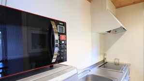 Een keuken met een Panasonic magnetron en een roestvrijstalen spoelbak.