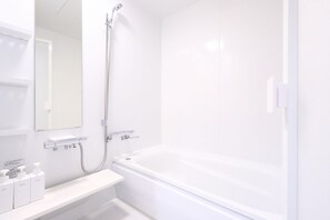 A modern bathroom with a bathtub, a showerhead, and a mirror.