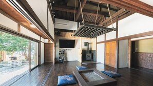 A spacious room with a large window, wooden flooring, and a suspended ceiling. - Glamping Villa Sameya Awaji (Sumoto)