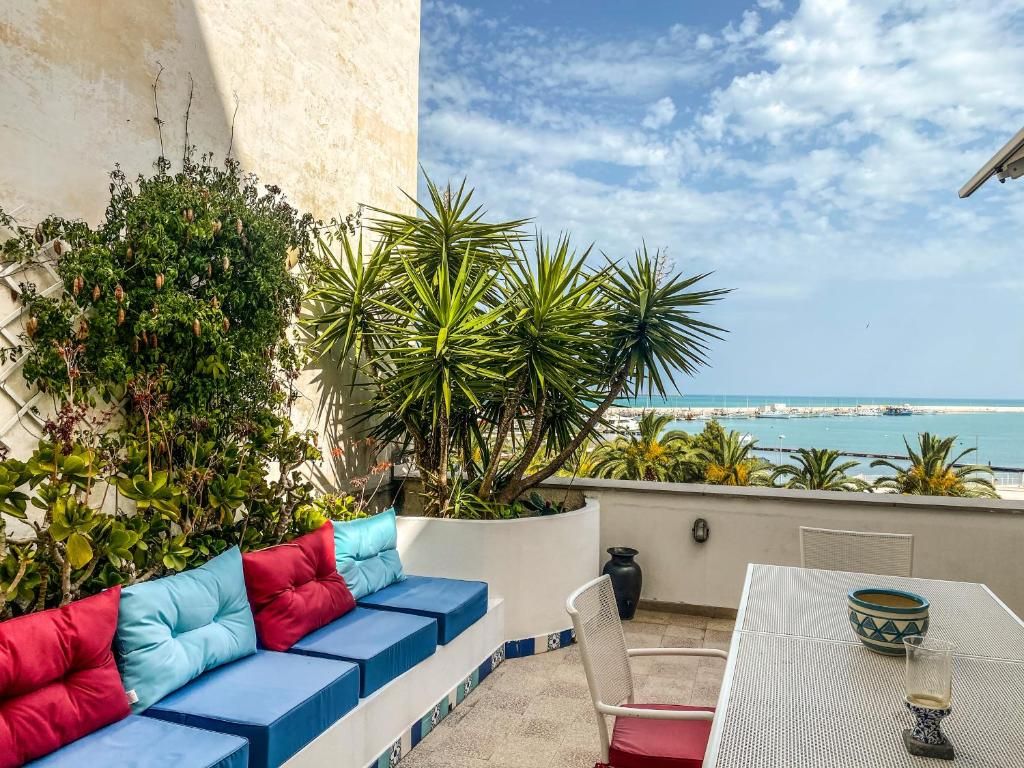 Un balcon avec un canapé, une table et une vue sur la mer.