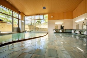 A spacious indoor swimming pool with clear views of the outdoors, wooden ceiling, and tiled floor. - Forest Cottage Oshu (Oshu)