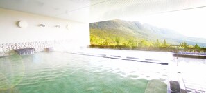 Une grande piscine intérieure offrant une vue sur un paysage montagneux.