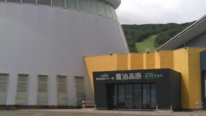 A modern building with a curved facade and a yellow entrance. - Geto Kogen Ski Resort (Kitakami)