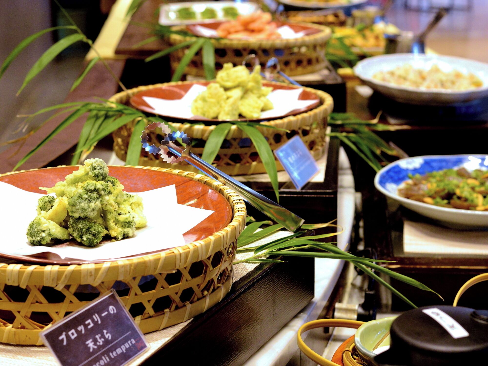 A buffet with various dishes, including a prominent pile of broccoli.