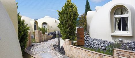 A row of dome-shaped buildings with a stone pathway leading to the entrance.