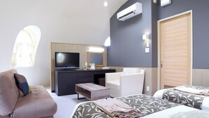 Ein Hotelzimmer mit Bett, Schreibtisch mit Fernseher, Stuhl und Kleiderschrank.