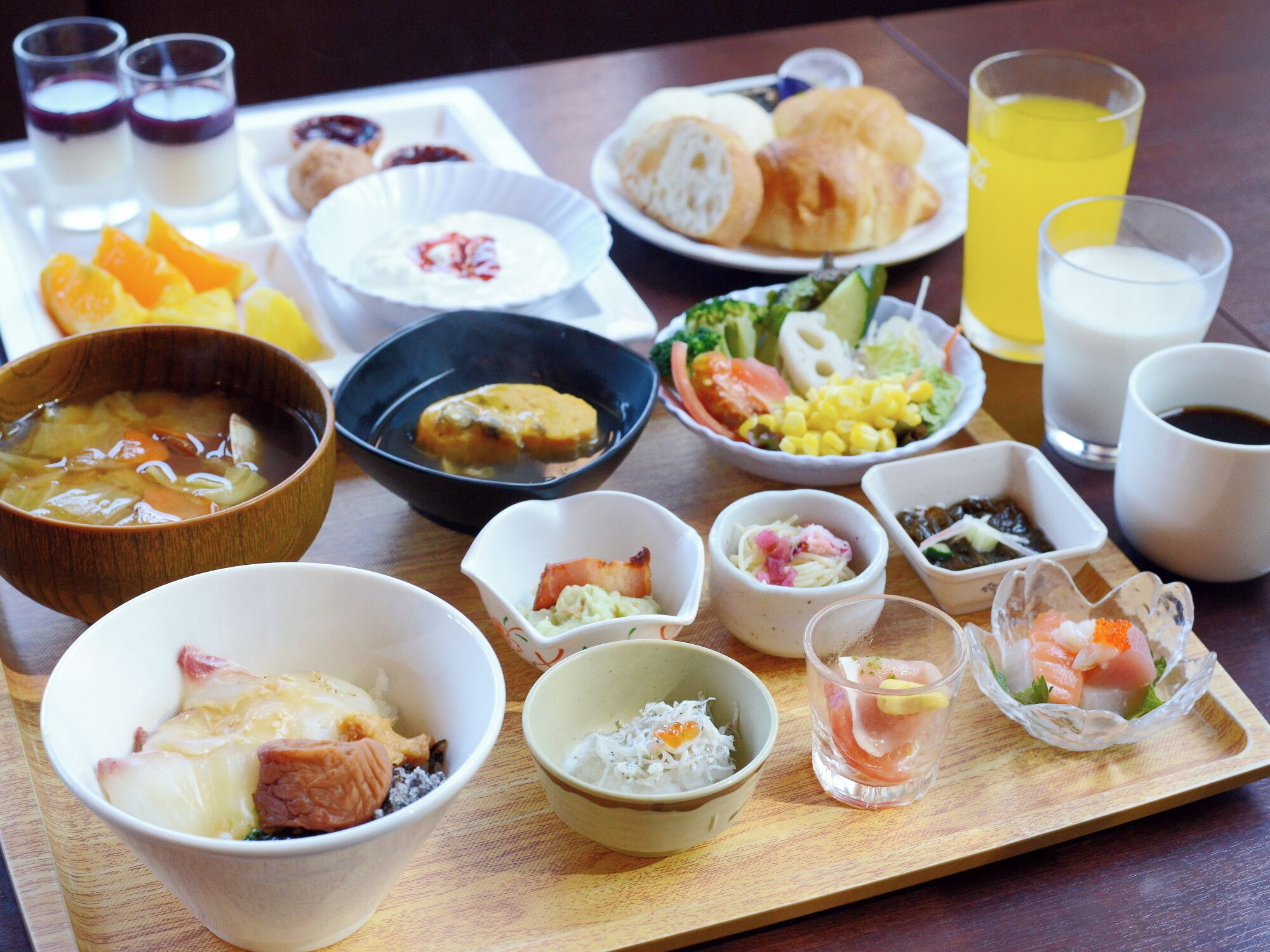 Una variedad de platos sobre una mesa de madera, incluyendo tazones de sopa, mariscos y ensaladas.