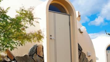 A building with a beige exterior, a stone wall, and a door.