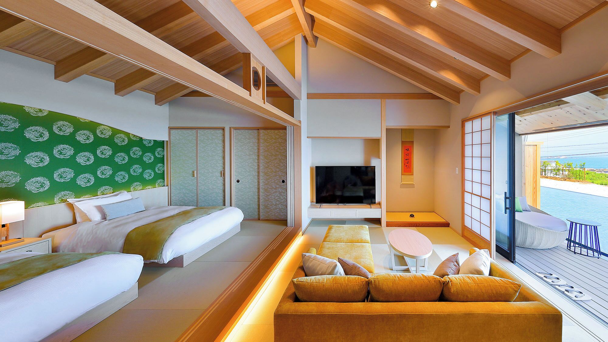 Une chambre d’hôtel moderne équipée d’un lit, d’un canapé, d’une télévision et offrant une vue sur la mer.