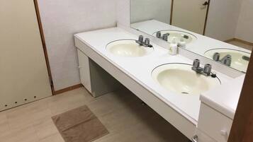 A bathroom with two sinks, a mirror, and a towel rack.