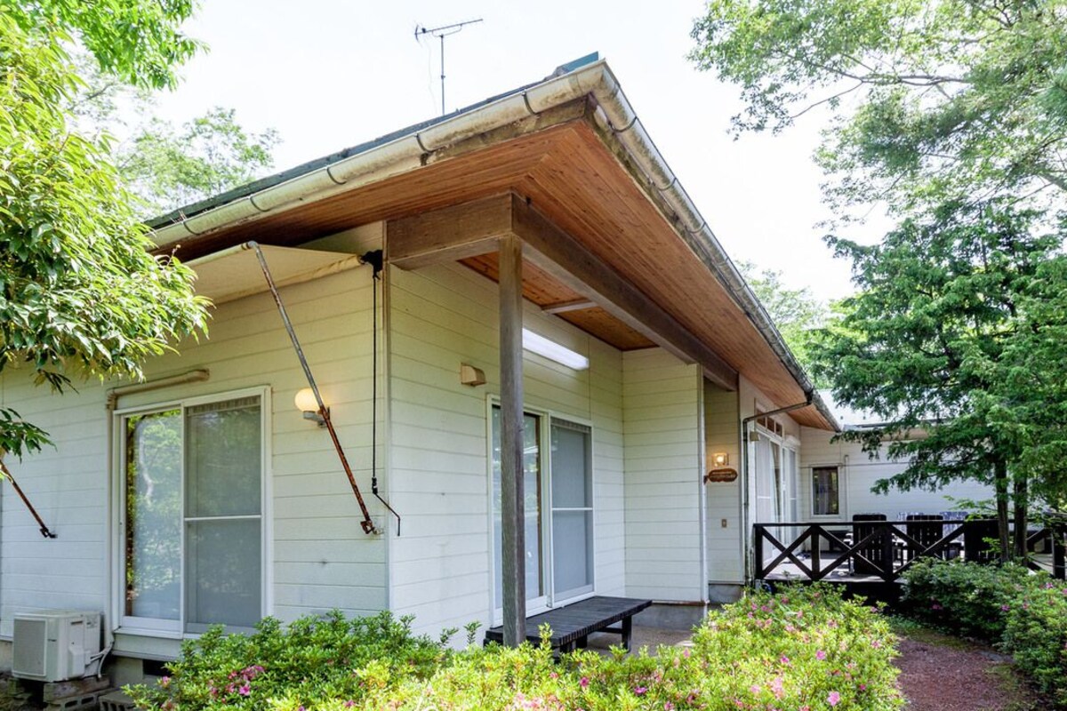 A single-story house with a porch, large windows, and a covered area.