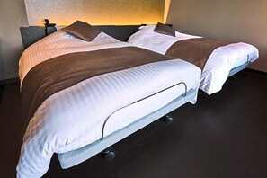 Un letto matrimoniale con una testiera scura, biancheria da letto bianca e marrone e un comodino con una lampada.
