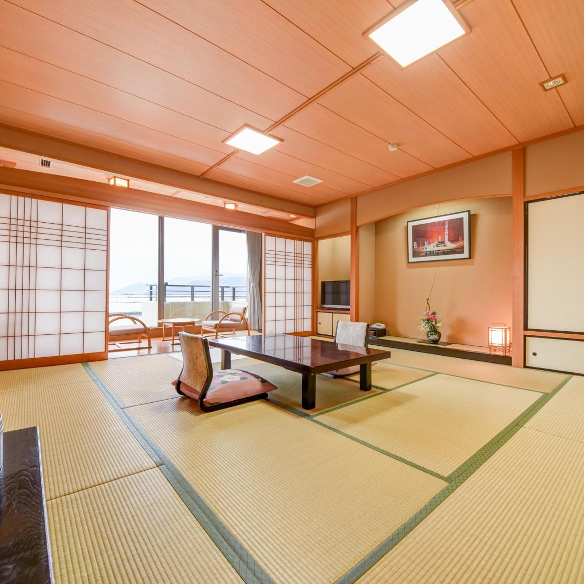 A traditional Japanese room with tatami flooring, a low table, and sliding doors.