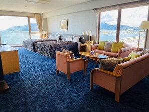 Una habitación de hotel con una cama, dos sofás, una mesa de centro y un escritorio.