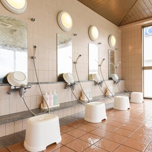 Des toilettes publiques équipées de plusieurs lavabos, de miroirs et de sèche-mains.
