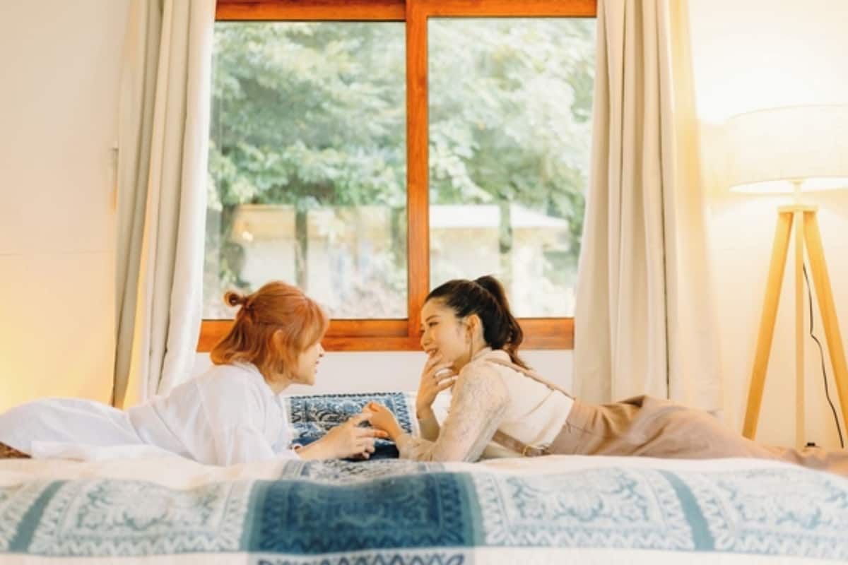 Una habitación con una cama, una ventana y una lámpara.