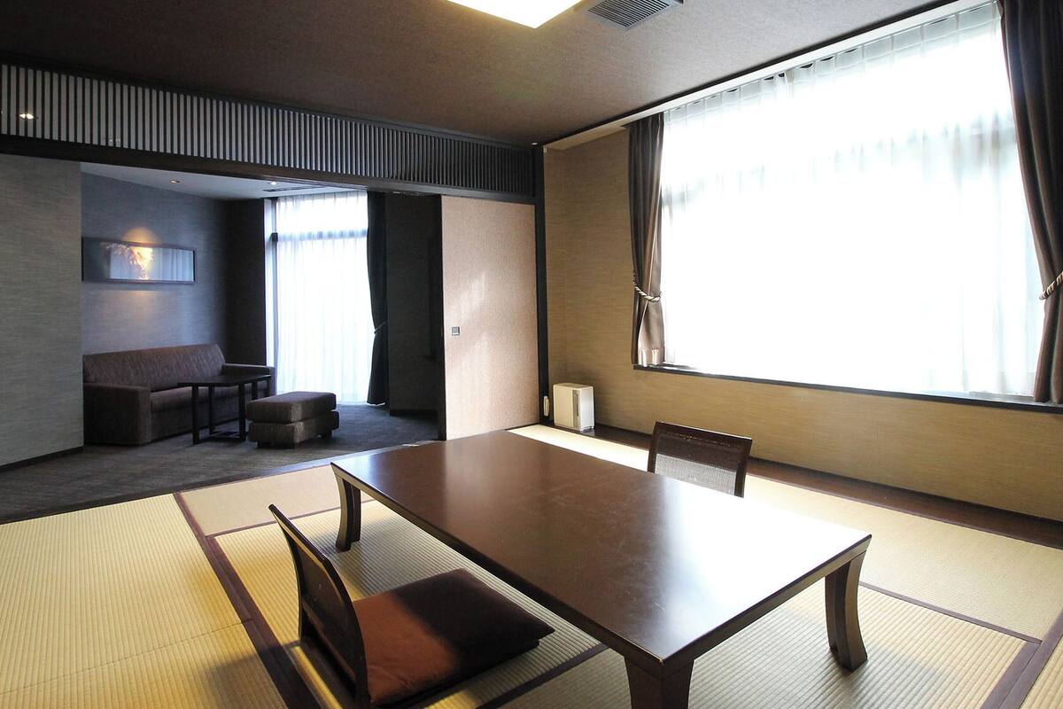 Een traditionele Japanse kamer met tatami vloeren, een lage tafel en een bank.