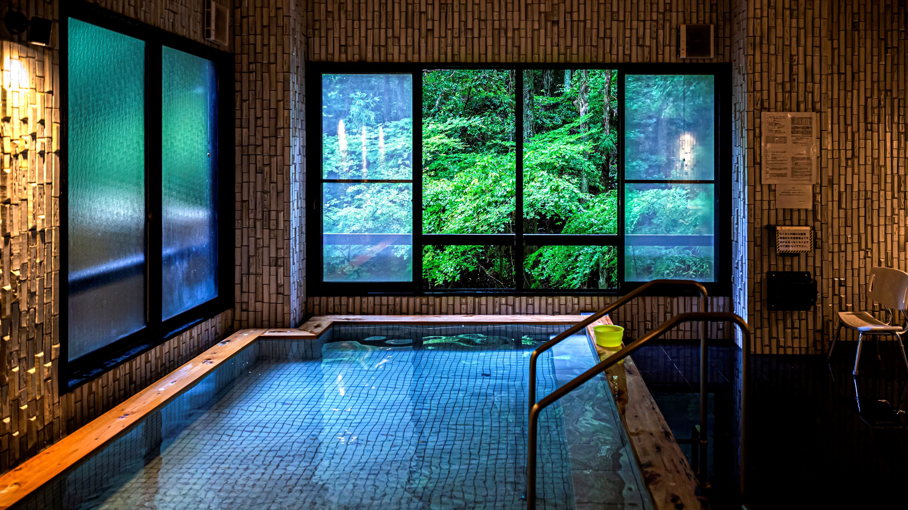 A spa area with a large window providing a view of a forest.
