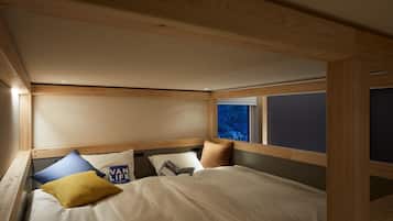 A compact bedroom with a bunk bed, wooden headboard, and a window with a view.