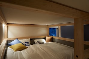 A compact bedroom with a bunk bed, wooden headboard, and a window with a view. - Hoshino Resort Beb5 Tsuchiura (Tsuchiura)