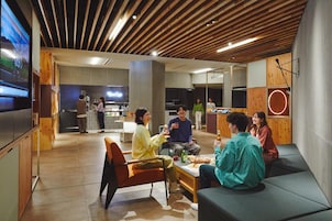 A modern interior with a seating area, a bar, and a television screen.