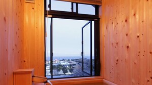 A wooden sauna room with a large window, a wooden bench, and a wooden table. - Izukogen Onsen Kura no Yado Hinata (Ito)