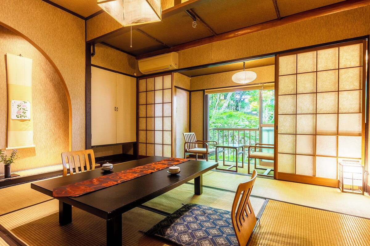 Une pièce de style japonais traditionnel, avec un sol recouvert de tatamis, une table basse et des portes coulissantes.