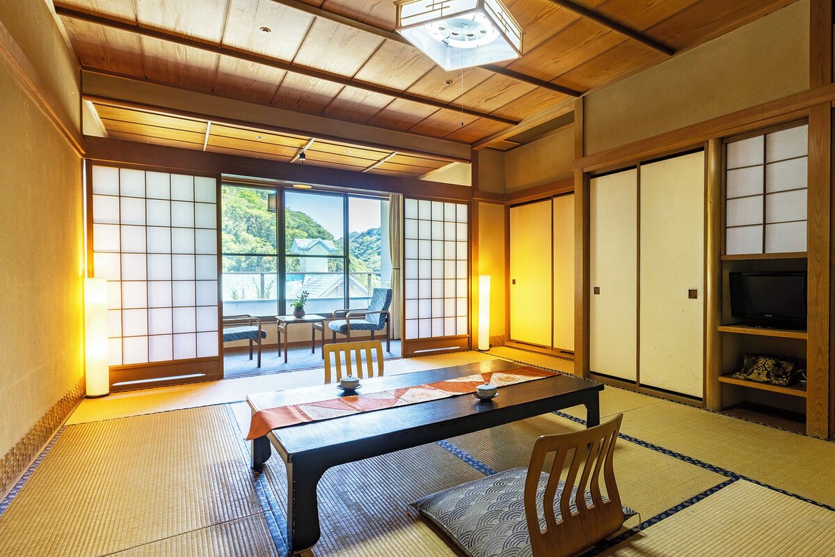 Una habitació japonesa tradicional amb tatami, una taula baixa i portes corredisses.