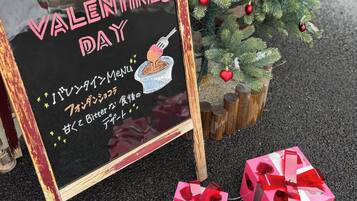 Un letrero de Día de San Valentín con un mensaje y un pequeño árbol de Navidad con adornos.