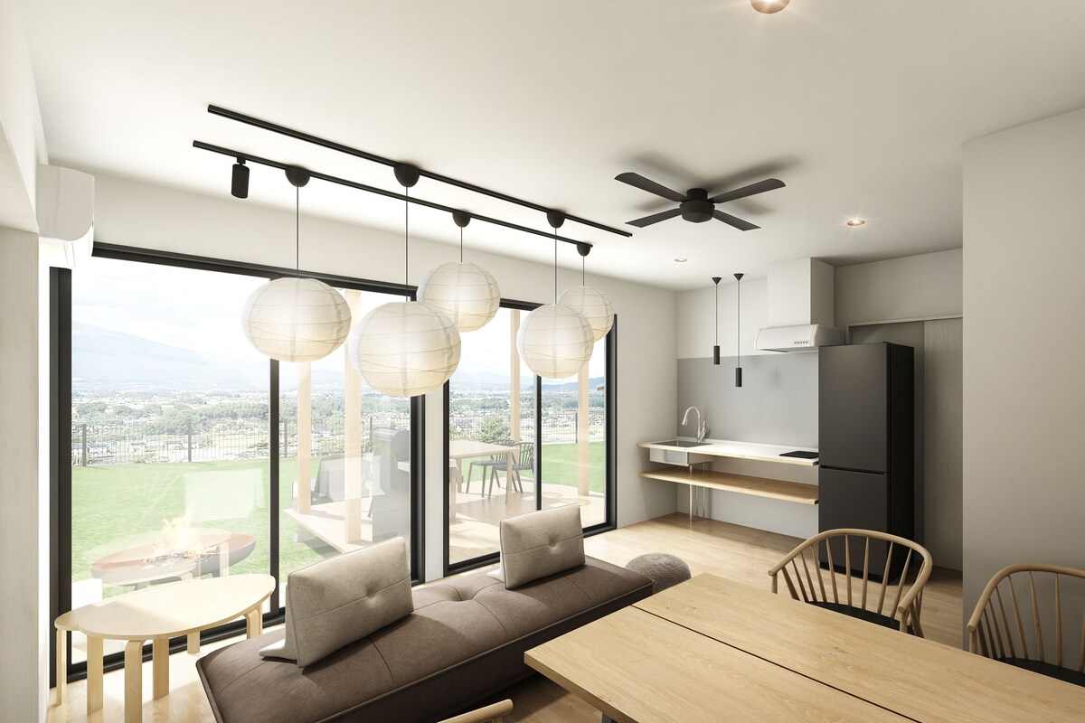 A modern kitchen with a built-in oven, a refrigerator, and a dining area with a wooden table and chairs.