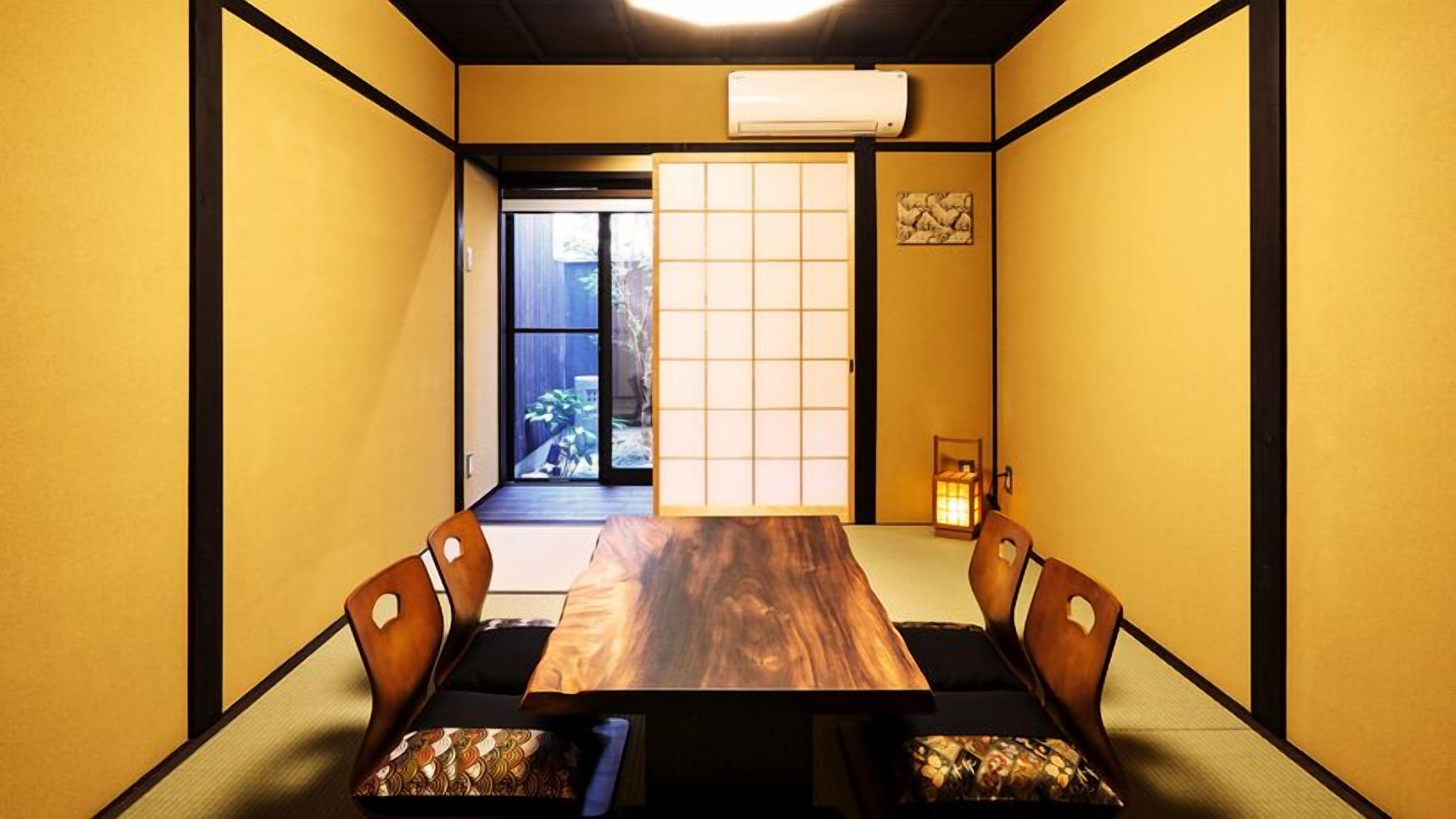 Ein traditioneller japanischer Raum mit Tatami-Boden, einem niedrigen Tisch und Shoji-Schirmwänden.