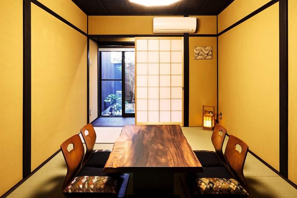 A traditional Japanese room with tatami flooring, a low table, and shoji screens.
