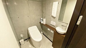 Moderni kylpyhuone, jossa on wc, pesuallas ja peili.