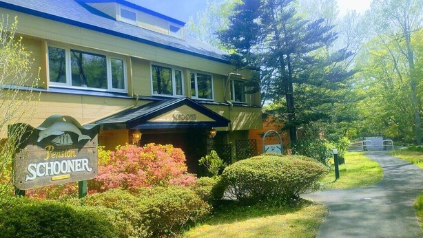 A building with a sign reading 'Schooner Pension' and a pathway leading to it. - Pension Schooner (Nasu)