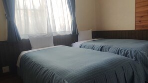 A room with two beds, a window with curtains, and a wooden wall. - Pension Schooner (Nasu)
