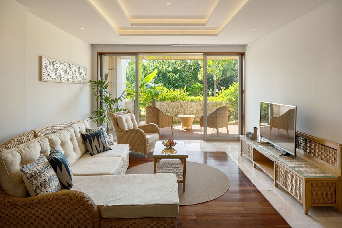 Un salon moderne comprenant un canapé, des fauteuils, une table basse et un téléviseur.