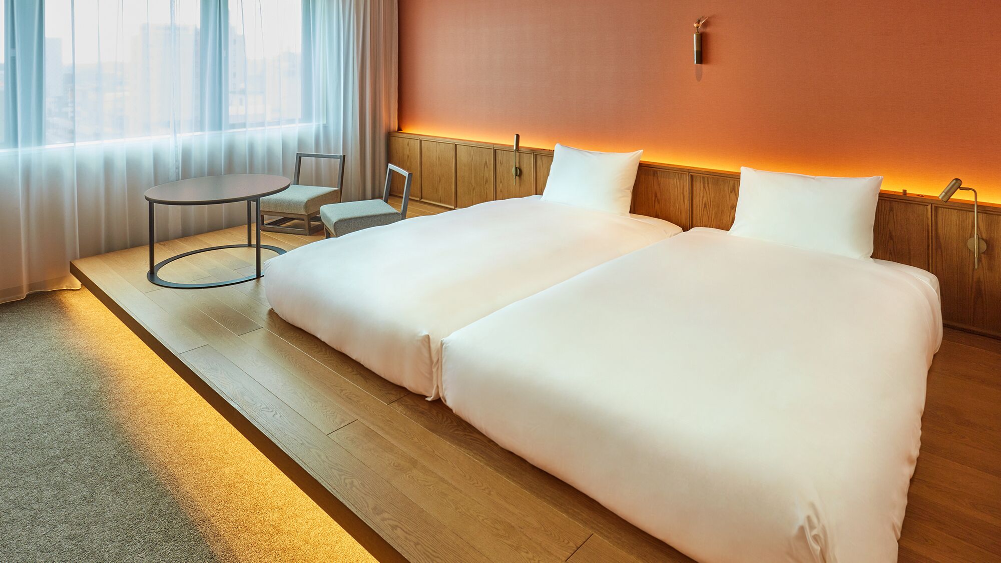 Une chambre d’hôtel avec un grand lit, une petite table ronde et une chaise.