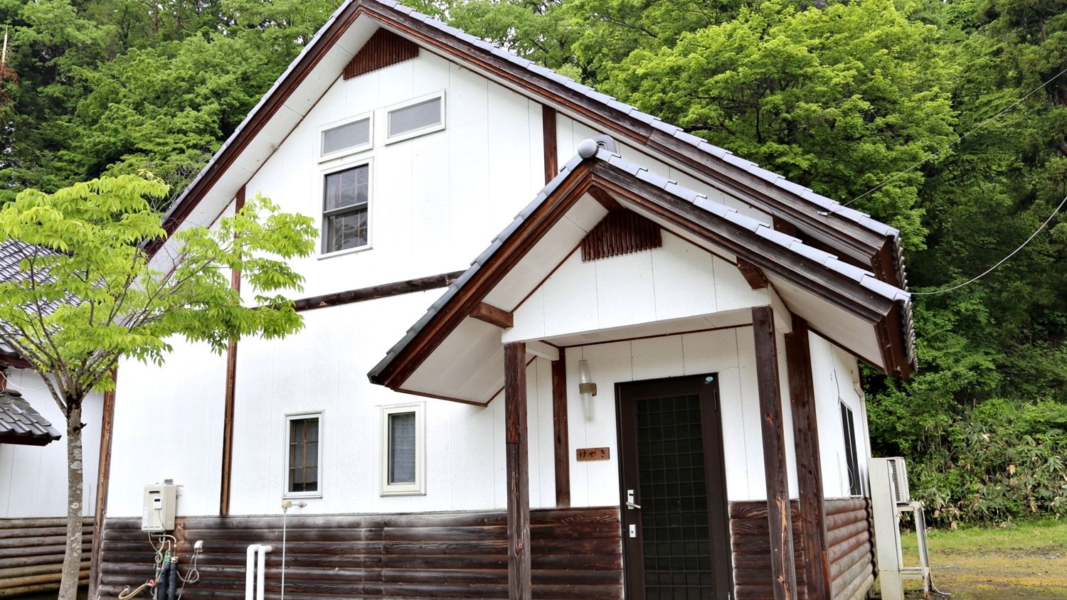 A two-story building with a white exterior and dark wooden trim.