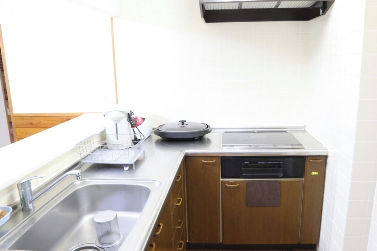 A compact kitchenette with a sink, a coffee maker, a toaster, and a small refrigerator.