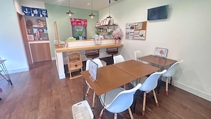 A dining area with a wooden table, blue chairs, and a counter with various items.