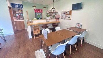 Un comedor con una mesa de madera, sillas azules y una encimera con diversos objetos.