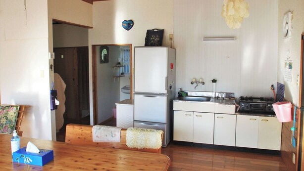 A compact kitchen with white cabinets, a refrigerator, a sink, and a stove. - Diving & Pension Riki (Setouchi)