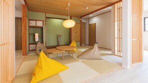 Una habitación tradicional japonesa con suelo de tatami, bajo techo de madera y puertas correderas.