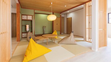 Una habitación tradicional japonesa con suelo de tatami, bajo techo de madera y puertas correderas.