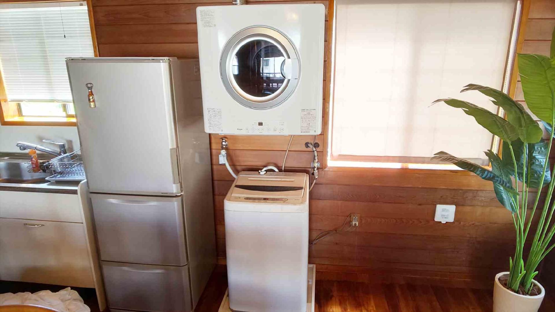 Una cocina compacta con refrigerador, lavadora y pileta.